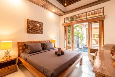 a bedroom with a large bed and a chair at PROMO DEAL Sweet Unique Hidden Gem 2 BD Villa - CONSTRUCTION NEARBY in Kerobokan
