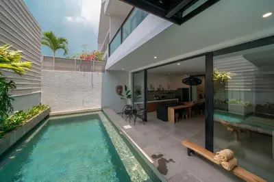 an infinity pool in the backyard of a house at Villa Athalla - Elegant 3BR Near Berawa Beach! in Canggu