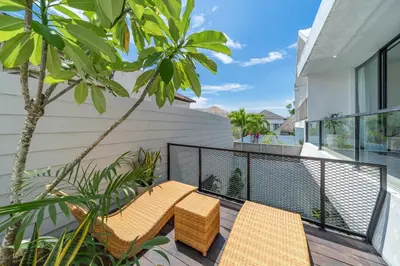 a balcony with two benches on a house at Villa Athalla - Elegant 3BR Near Berawa Beach! in Canggu