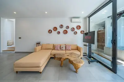 a living room with a couch and a table at Villa Athalla - Elegant 3BR Near Berawa Beach! in Canggu