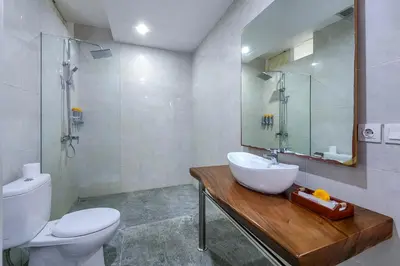 a bathroom with a sink and a toilet and a mirror at Villa Emilia Seminyak by Nagisa Bali in Kerobokan
