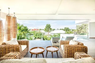 a living room with rattan furniture and a patio at New Brawah 5 BR Villa 200m to Finns Beach Club in Canggu