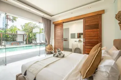 a bedroom with a large bed and a pool at New Brawah 5 BR Villa 200m to Finns Beach Club in Canggu