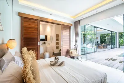 a bedroom with a large bed and a balcony at New Brawah 5 BR Villa 200m to Finns Beach Club in Canggu
