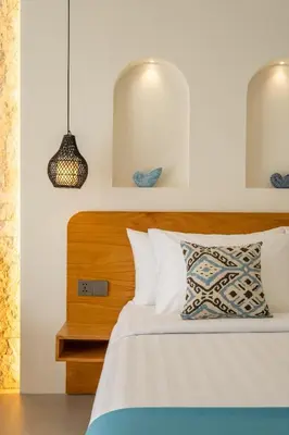 a bedroom with a bed with a wooden headboard at Mysa Boutique Hotel in Seminyak