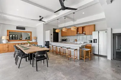 a kitchen with a table and chairs and a kitchen with a refrigerator at Abu Villa by Betterplace in Canggu