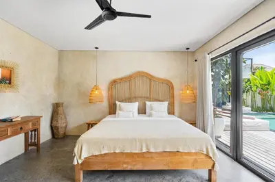 a bedroom with a bed and a balcony at Abu Villa by Betterplace in Canggu