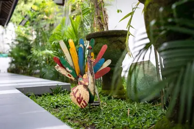 a group of colorful birds sitting in the grass at Little Boutique Hotel No 101 in Canggu
