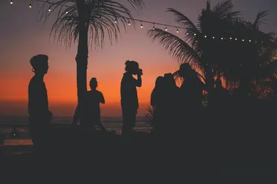 a silhouette of a wedding party on the beach at sunset at Little Boutique Hotel No 101 in Canggu