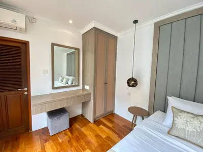 a bedroom with a bed and a mirror at Mila's Villa in Legian