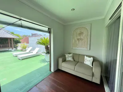 a living room with a couch and a sliding glass door at Mila's Villa in Legian