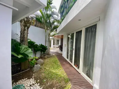 a house with a wooden walkway next to a building at Mila's Villa in Legian