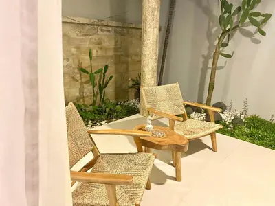 a group of chairs and a table on a patio at Mila's Villa in Legian