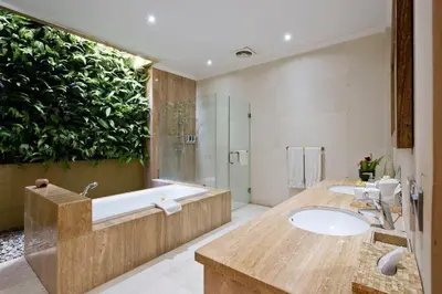 a bathroom with two sinks and a green wall at Zolina Villa 4 Bedrooms in Kerobokan