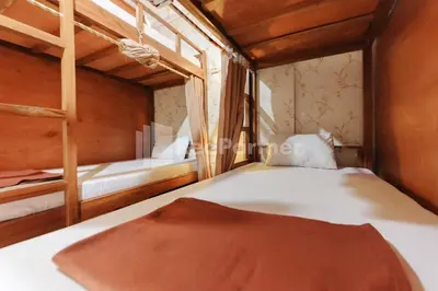 a bedroom with two bunk beds and a window at Shooting Star Hostel Kuta RedPartner - mixed dormitory in Legian