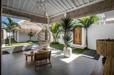 a living room with a patio with palm trees at Villa Makena by Alfred in Bali in Seminyak