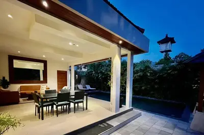 a patio with a table and chairs and a living room at Villa Plawa in Seminyak