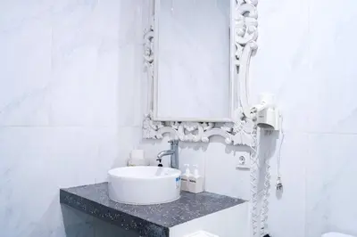 a white bathroom with a sink and a mirror at Villa between seminyak & canggu in Seminyak