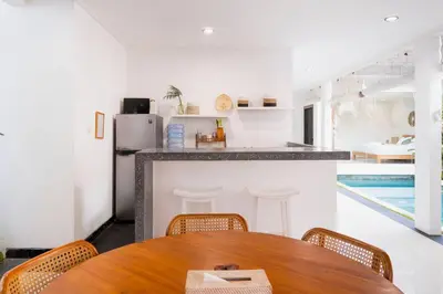 a dining room with a table and a kitchen at Villa between seminyak & canggu in Seminyak