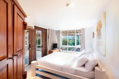 a bedroom with a bed with white sheets and pillows at Seminyak Villa Kubuku in Seminyak