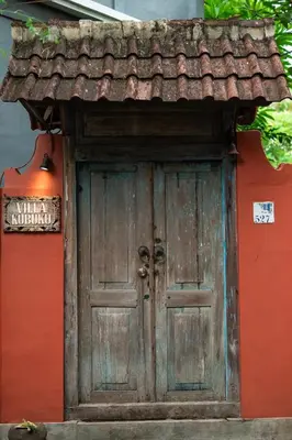 an old wooden door with a roof on a house at Seminyak Villa Kubuku in Seminyak