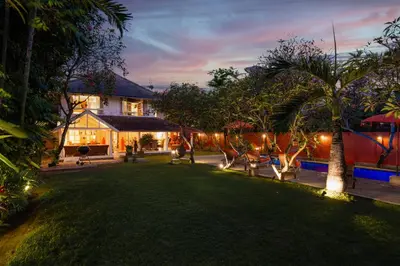 a backyard of a house with a lawn and trees at Seminyak Villa Kubuku in Seminyak