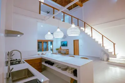 a kitchen with white counters and a staircase at Villa Amil Seminyak in Seminyak
