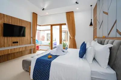 a bedroom with a white bed and a television at Villa Waldo - 6 bedroom High End Luxury Villa in Batu Belig, Seminyak in Canggu