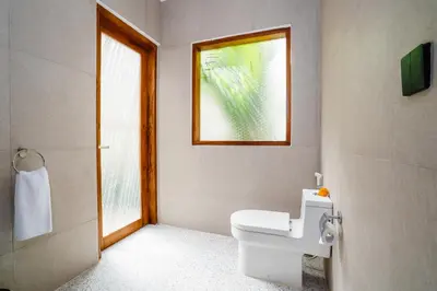 a bathroom with a toilet and a window at Villa Waldo - 6 bedroom High End Luxury Villa in Batu Belig, Seminyak in Canggu
