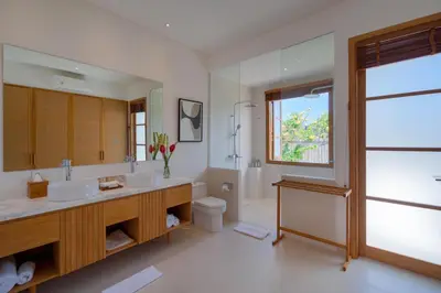 a bathroom with two sinks and a toilet and a window at Amenara Estate by LifestyleRetreats in Canggu