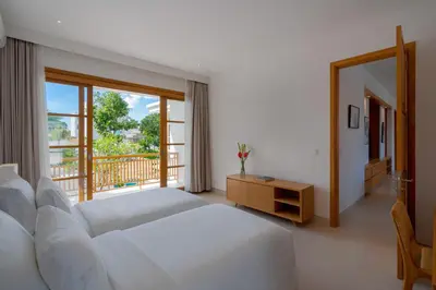 a bedroom with a white bed and a balcony at Amenara Estate by LifestyleRetreats in Canggu