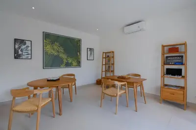 a dining room with two wooden tables and chairs at Amenara Estate by LifestyleRetreats in Canggu
