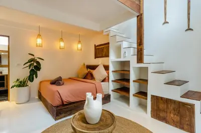 a bedroom with a bed and a spiral staircase at Villa Micasa - Tropical Oasis 4BR Villa with Private Pool, Perfect for Big Groups, 12 Minutes to the Beach in Kerobokan