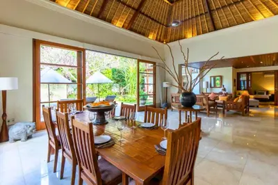 a dining room and living room with a wooden table and chairs at Magnificent 4 BR Private Pool Villa NE10 in Jimbaran
