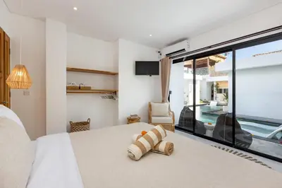 a bedroom with a bed and a large window at Villa Kelolyne in Seminyak