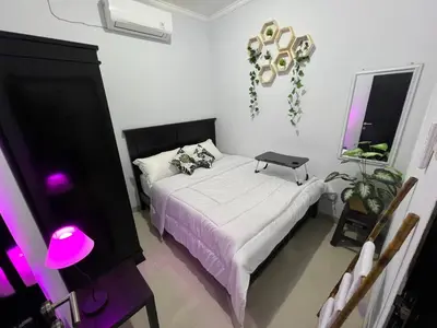 a bedroom with a bed with a laptop on it at Chandra's guest house in Pesanggaran