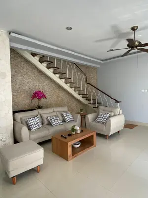 a living room with two couches and a staircase at Villa Granatlia in Sanur