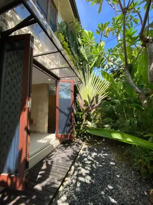 an open door to a house with a garden at Villa Granatlia in Sanur