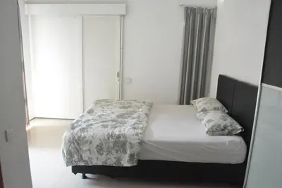 a bedroom with a bed with a blanket and pillows at Bracha house in Legian