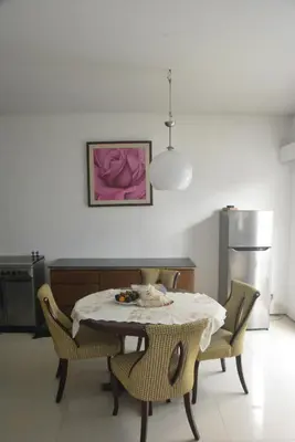 a kitchen with a table with chairs and a refrigerator at Bracha house in Legian