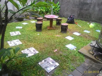a garden with a table and some cards on the grass at Bracha house in Legian