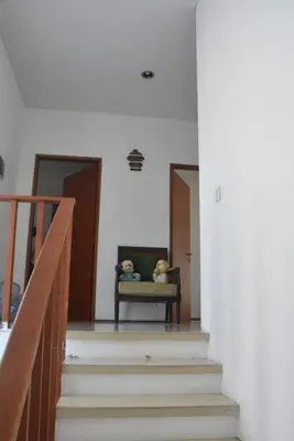 a stairway with a chair with two teddy bears on it at Bracha house in Legian