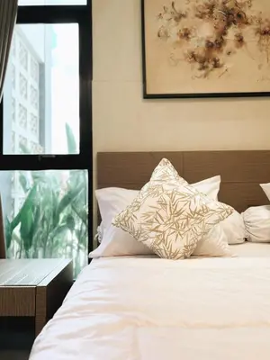 a bed with white sheets and pillows in a bedroom at Nawasena Room Suite in Sanur