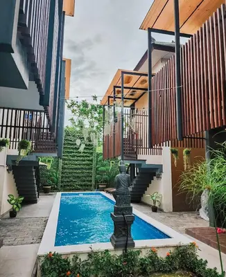 a swimming pool in the middle of a house with a fountain at Nawasena Room Suite in Sanur