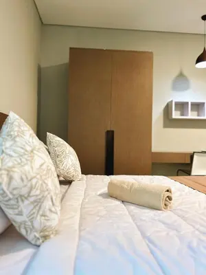 a white bed with a rolled up towel on it at Nawasena Room Suite in Sanur