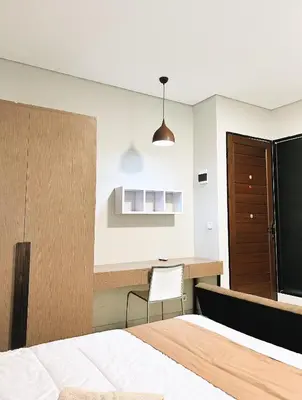 a bedroom with a bed and a desk and a chair at Nawasena Room Suite in Sanur