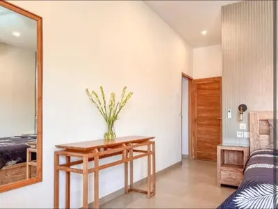 a room with a table with a vase of flowers on it at Villa Dekat Pantai Batu Belig in Canggu