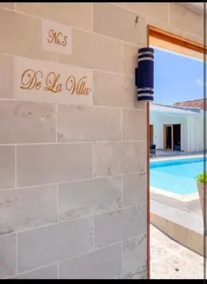 a stone wall with a sign that reads die la villa at Villa Dekat Pantai Batu Belig in Canggu