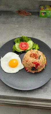a plate of food with a fried egg and vegetables at Villa Dekat Pantai Batu Belig in Canggu