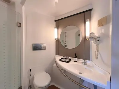 a bathroom with a sink and a toilet and a mirror at Luminor Hotel Legian Seminyak - Bali in Legian